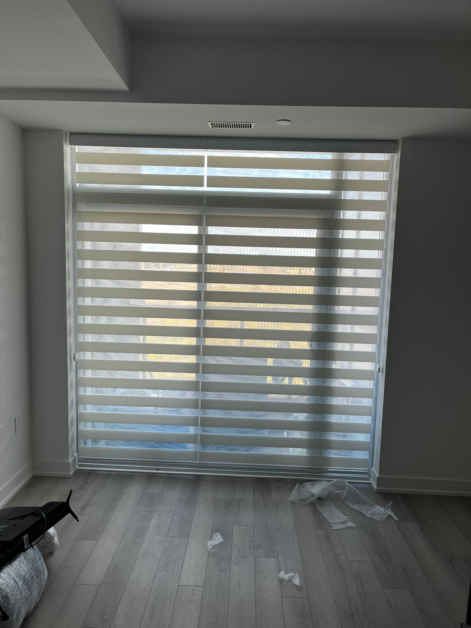 White zebra blinds fitted across a bright multi-panel window