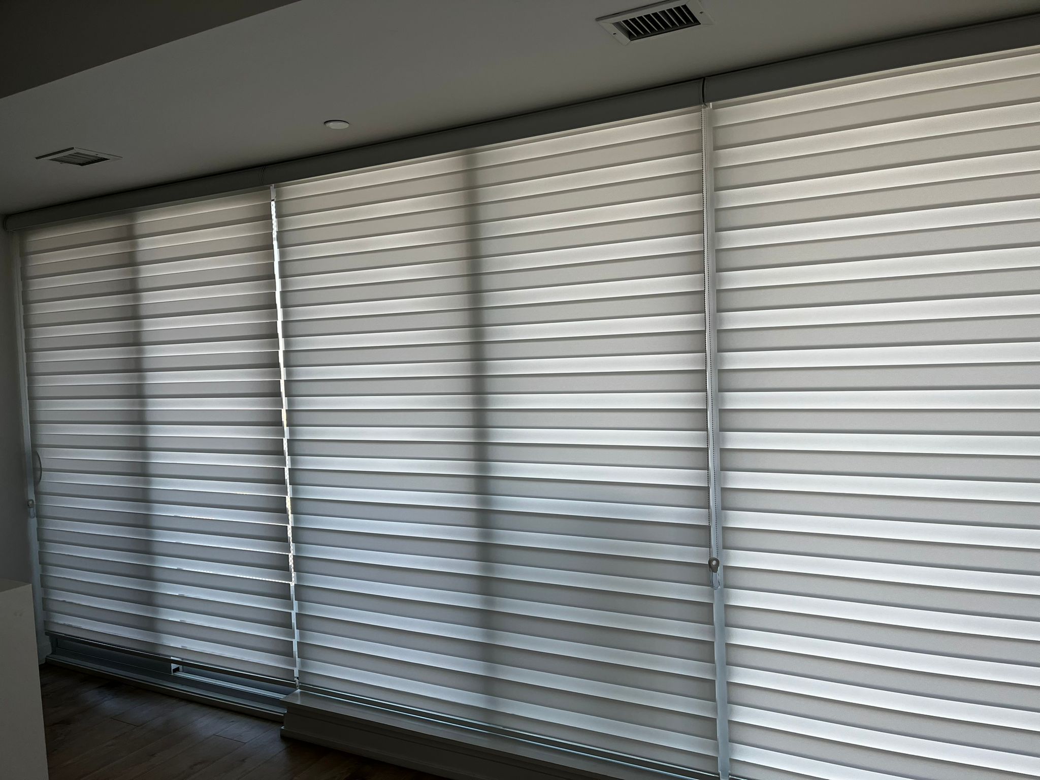 Zebra blinds fitted across a wide panoramic window