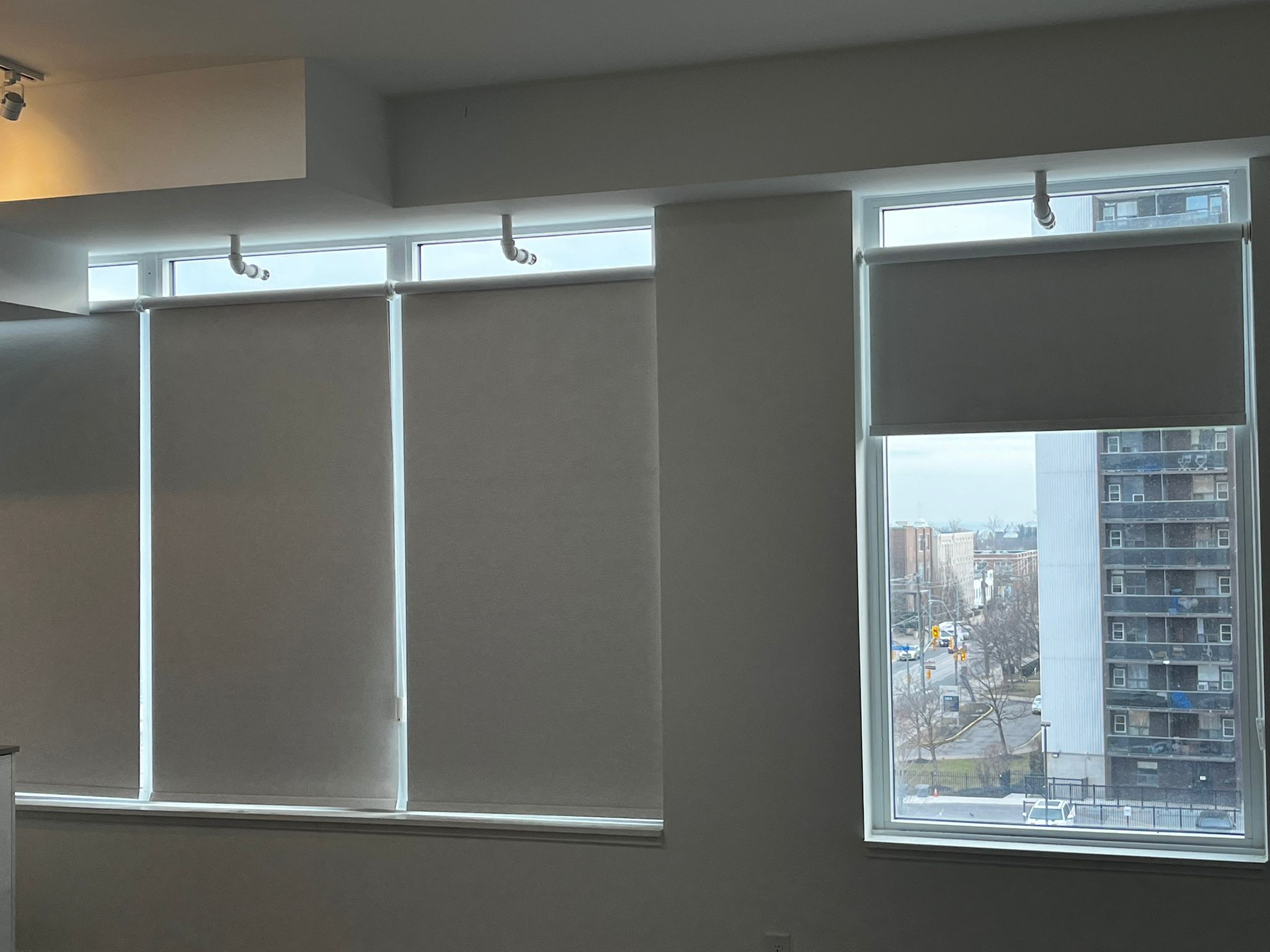 Coordinated roller shades installed across condo windows